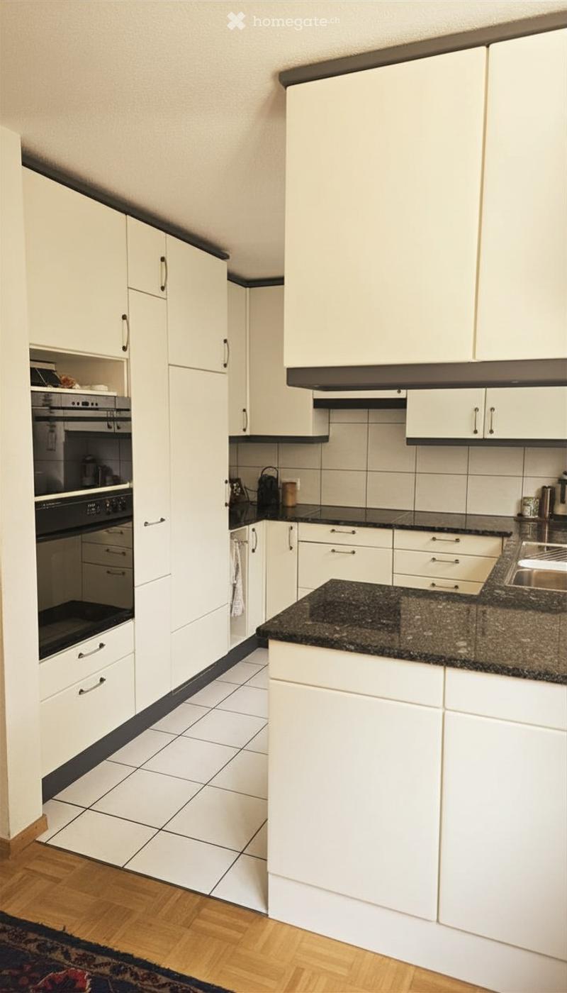 Modern kitchen with white cabinets, granite countertop, and stainless steel appliances.