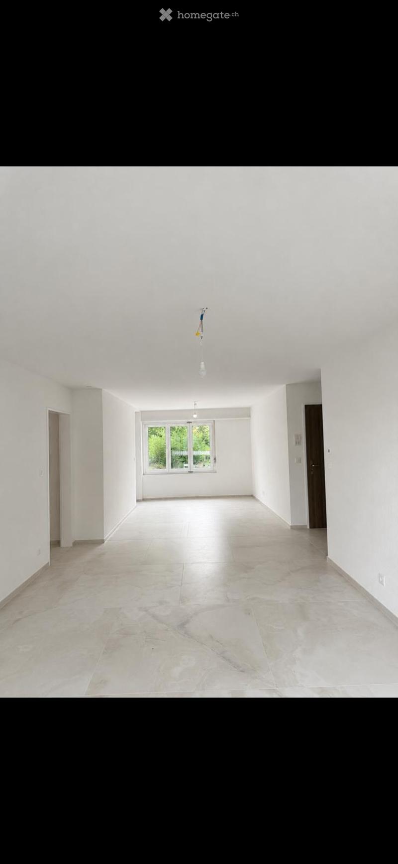 Empty room with white walls, large window, and tiled floor. No furniture or equipment present.