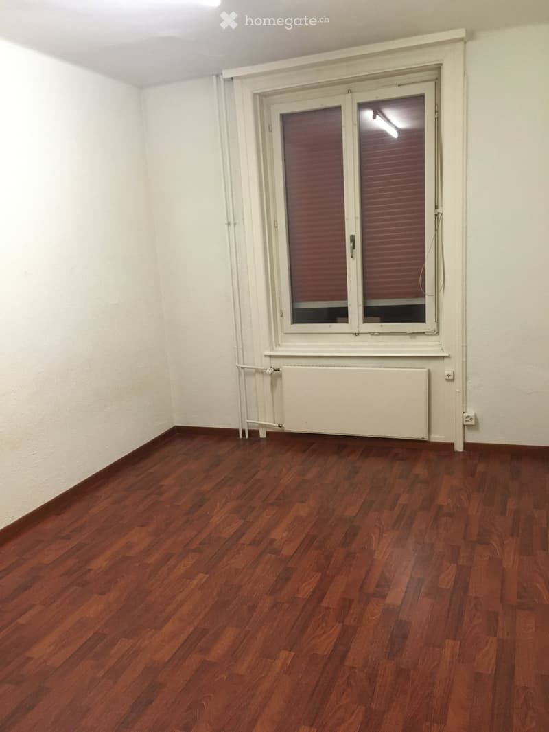 empty room, wooden floors, white walls, window with red blinds, white radiator