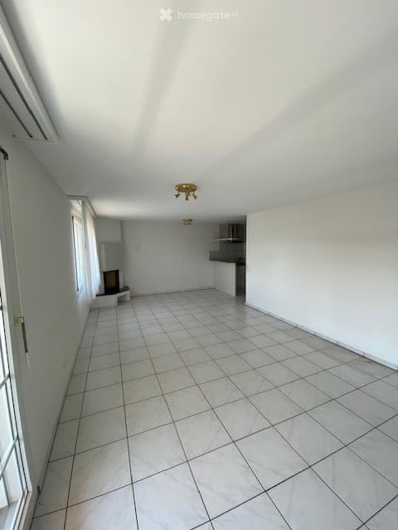 Completely empty room with white tiled flooring, white walls, and a small built-in shelf unit. No furniture or equipment is present.