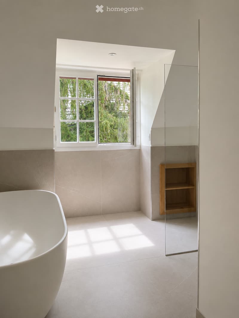 Modern bathroom with a freestanding bathtub, large window, glass shower enclosure, and a wooden shelf.