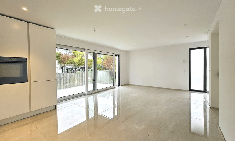 Empty room with large sliding glass doors, polished tile floor, and modern cabinetry on one side.