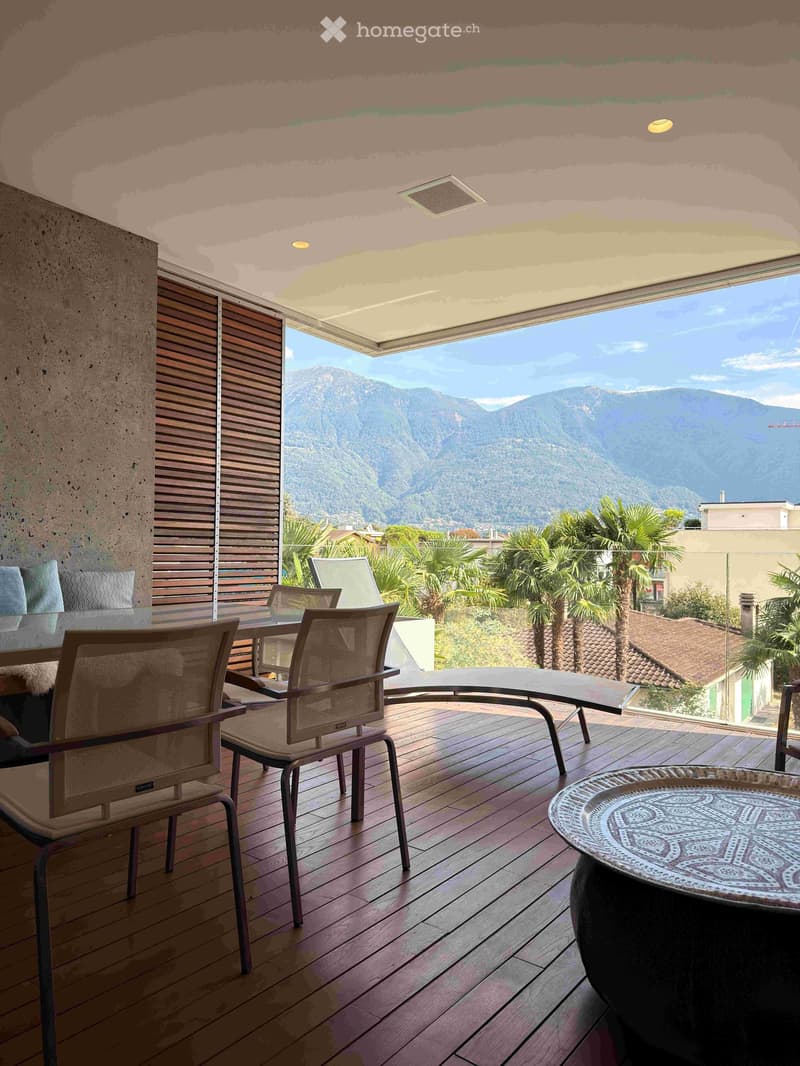 Wooden deck terrace with outdoor furniture, overlooking a scenic mountain view.