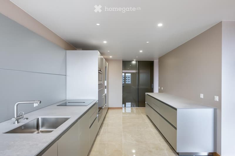 Modern kitchen with white cabinets, stainless steel sink, and sleek countertops.