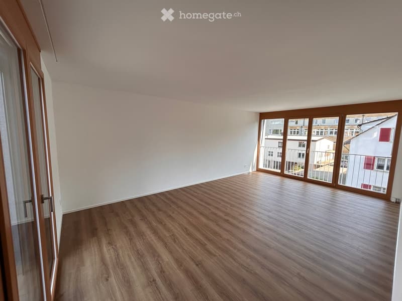 large glass windows, balcony, hardwood floor, white walls