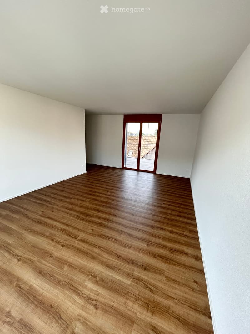 empty room, wooden floor, sliding glass door leading to balcony, white walls