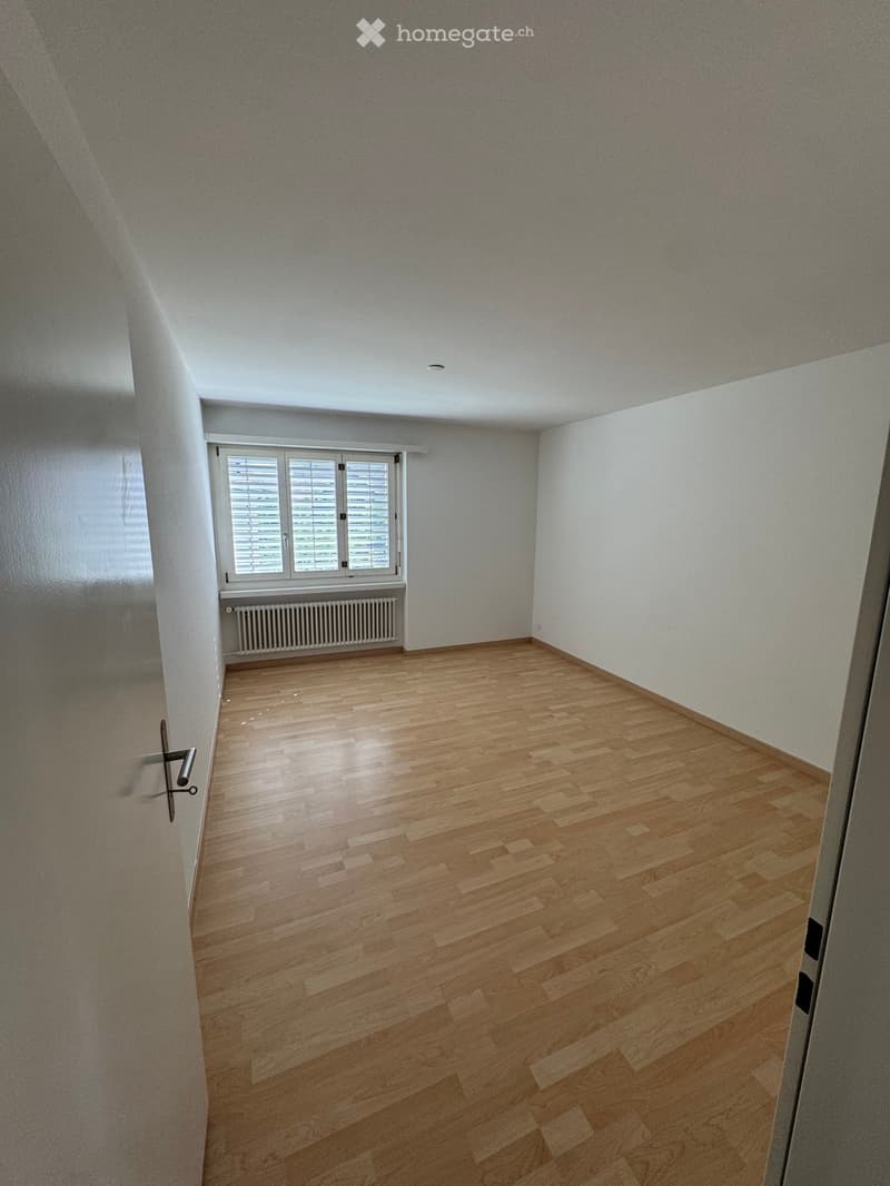 Empty room with wooden flooring, white walls, and a window with blinds. No furniture or equipment is present.