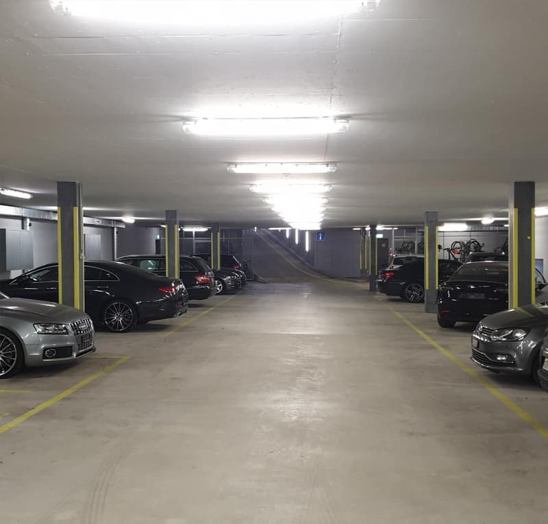 {"visible_features": ["Garage", "Parking place"], "type": "Garage", "objects": [], "description": "Underground parking garage with multiple parked cars, yellow painted parking lines, and overhead lighting.", "localized_descriptions": {"EN": "Underground p