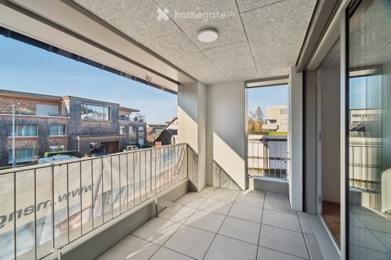 Empty balcony with metal railings, tiled floor, view of the outside.