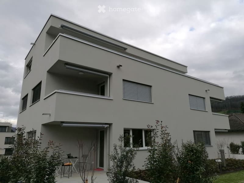 2 story house, white paint, large windows, balcony, table and chairs