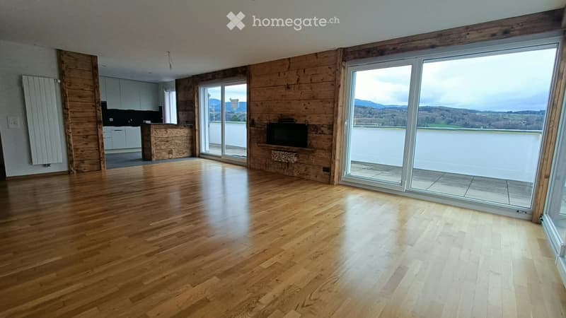 Empty room with wooden flooring, large windows offering a scenic view, and a modern design with wooden paneling and built-in TV.