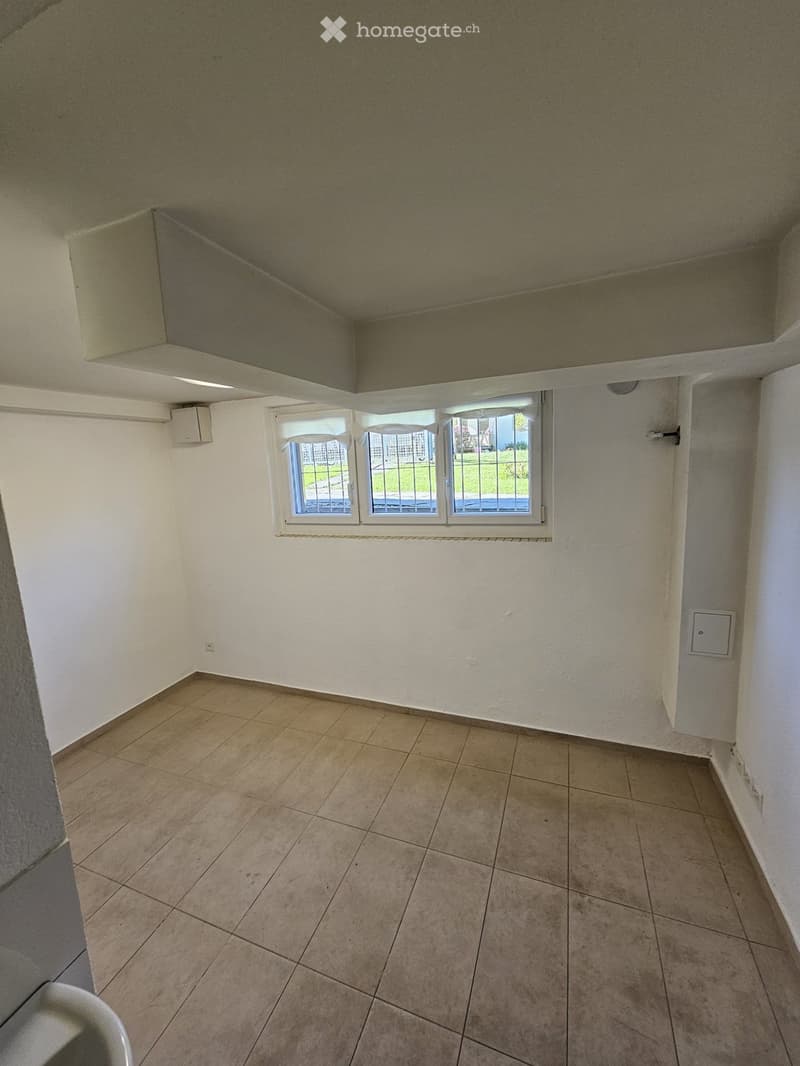 Empty room with tiled floor, white walls, and a window with blinds. No furniture or equipment present.