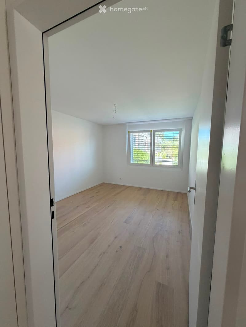 Empty room with wooden flooring, white walls, and a window with blinds. No furniture or equipment is present.