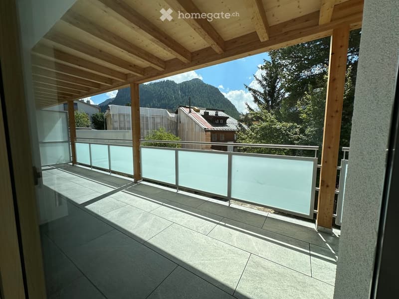 Balcony with wooden ceiling, glass railing, tiled floor, and scenic mountain view.