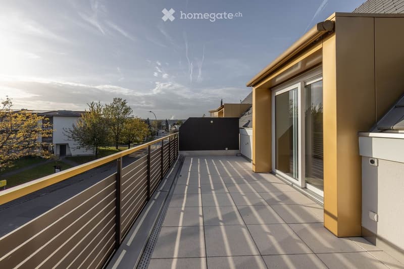 Modern balcony with tiled floor, metal railing, and glass door leading to a building.