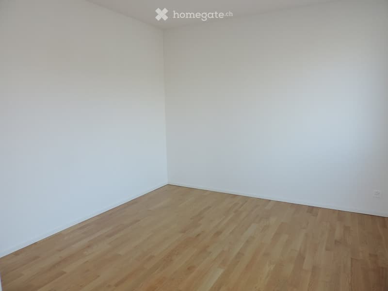 Empty room with white walls and light wooden flooring, no furniture or equipment present.