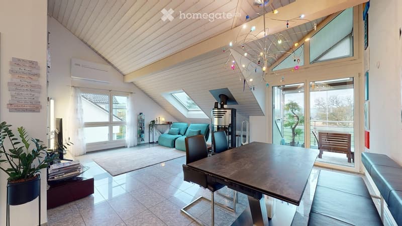 Bright, modern living space with a slanted wooden ceiling, large windows, and skylights. Features a sofa, dining table, chairs, a bench, and decorative plants.