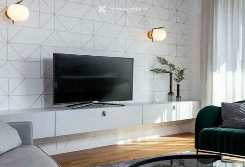 Modern living room with a grey sofa, coffee table, flat-screen TV on a white cabinet, wall-mounted lamps, and a potted plant in a vase.
