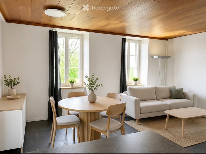 Modern living and dining area with a light-colored sofa, coffee table, round dining table with chairs, and decorative vases and plants.