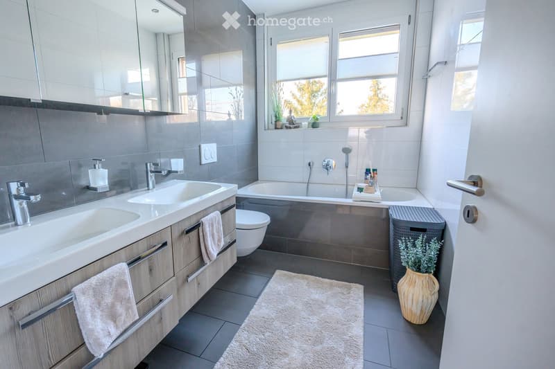 Bathtub, sink, white tiles, towel racks, shower, plant, window