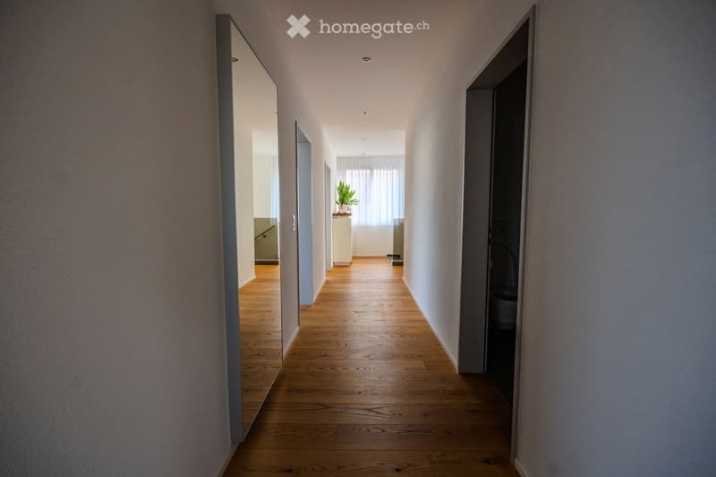 white walls, wooden floors, mirror, white door, open door with window, potted plant