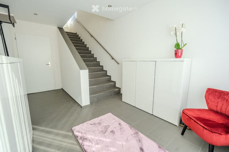 tiled floor, staircase, white doors, red chair, flower vase