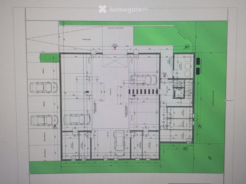 Floor plan of a residential building with multiple rooms, including living spaces, bedrooms, bathrooms, and parking areas.