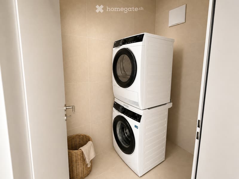 A small, modern laundry room with a stacked washing machine and dryer, a wicker basket with a towel, and beige tiled walls and floor.