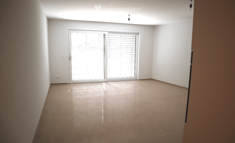 Empty room with white walls, tiled floor, and large sliding glass door with blinds.