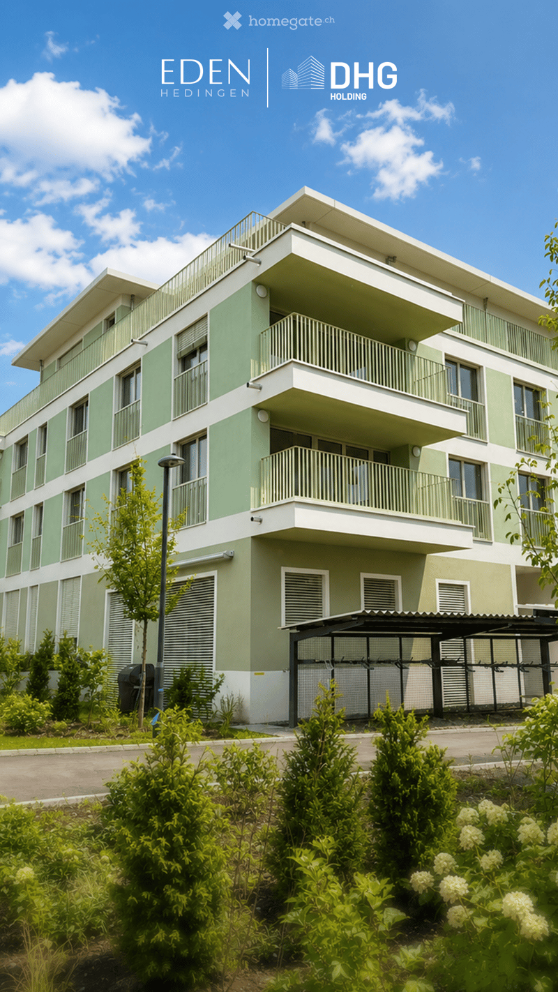Modern two-story residential building with green and white exterior, multiple balconies, and surrounding greenery.