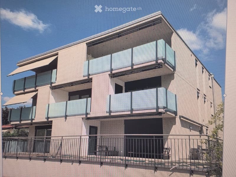 Modern multi-story building with balconies, large windows, and awnings, featuring a contemporary design with clean lines and a neutral color palette.