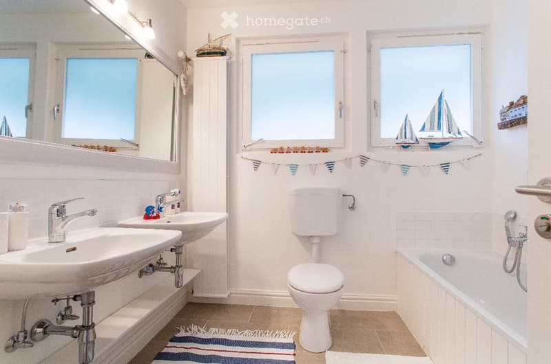 Two wash basins, white bath, white toilet, mirror, window