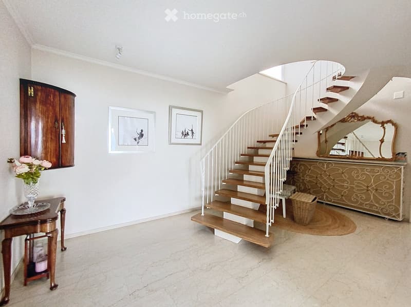 white walls, wooden stairs, mirror on wall, flower vase, brown wooden cabinet