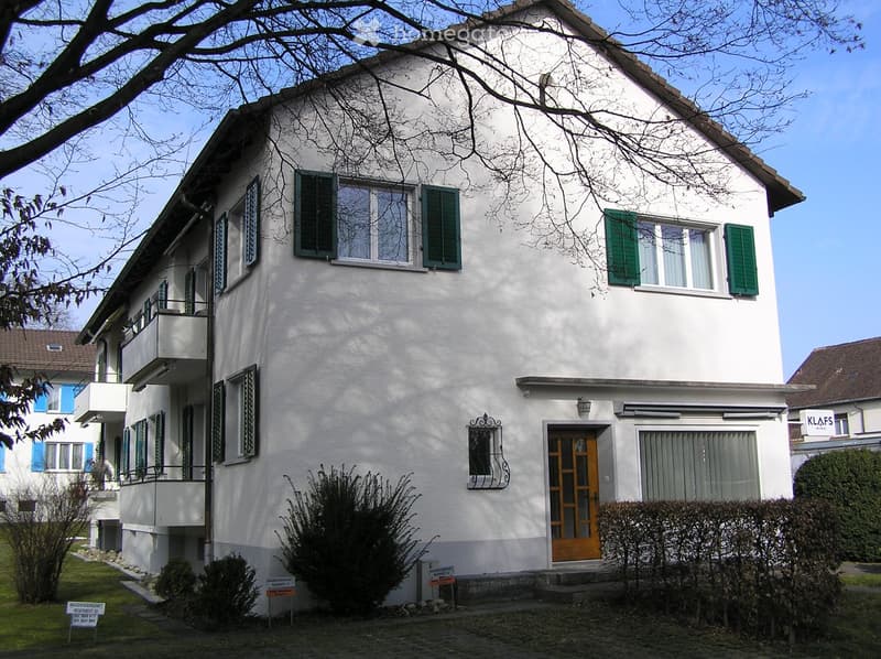Three story house, white exterior, green shutters, wooden door, multiple balconies