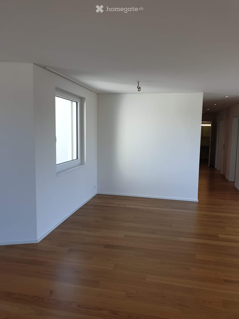 Empty room with wooden flooring, white walls, and a single window letting in natural light. No furniture or equipment is present.