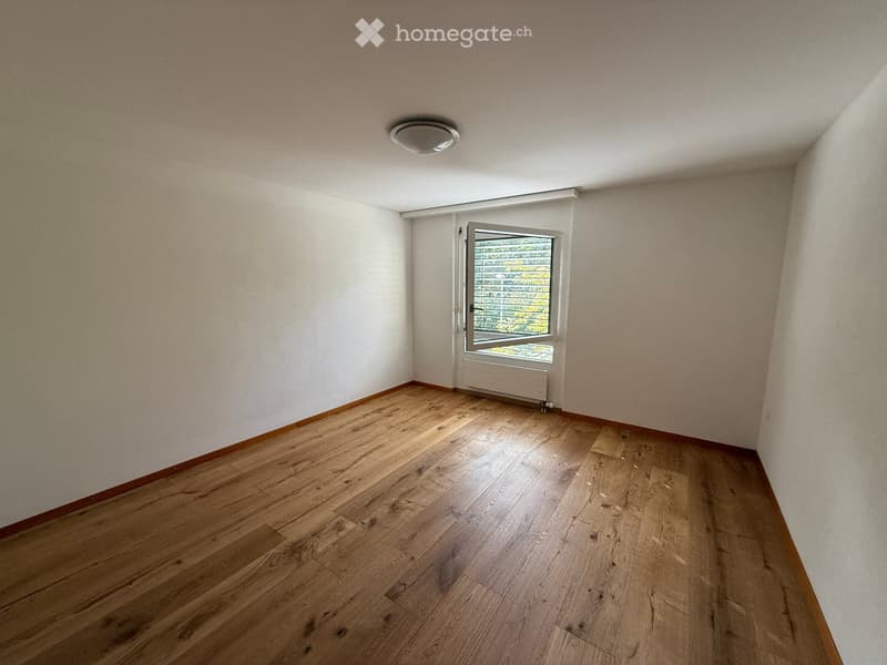 Empty room with wooden flooring, white walls, and a window with blinds. No furniture or equipment present.