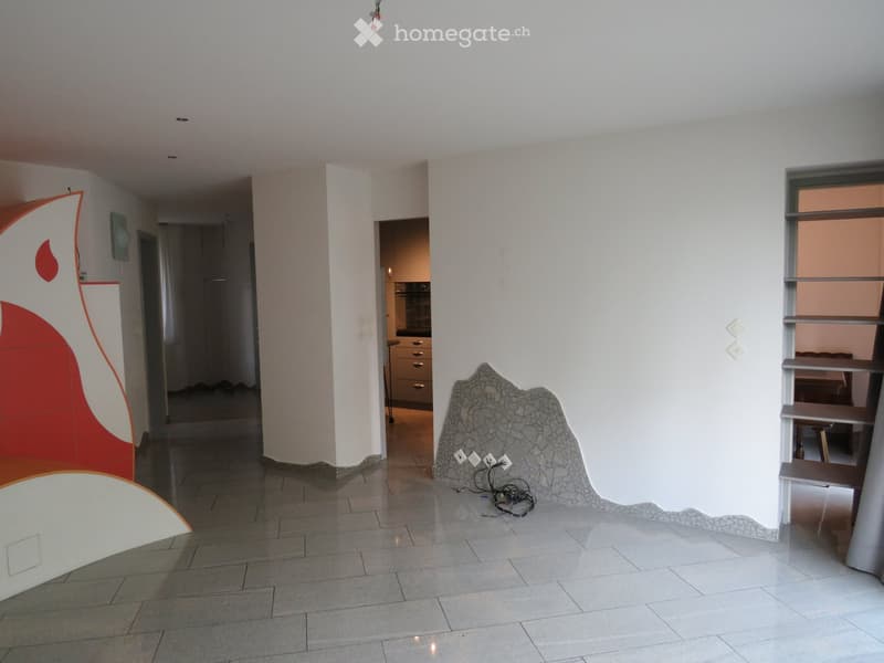 Empty hallway with tiled floor, white walls, and a decorative stone wall piece. No furniture or equipment visible.