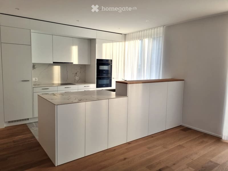modern kitchen with white cabinets, marble countertop, wooden floor, white walls, windows with curtains, built-in oven, and a marble backsplash