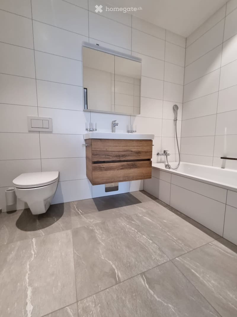modern bathroom with white tiles, wooden vanity, walk-in shower, bathtub, toilet, large mirror