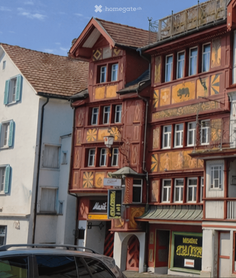 A row of traditional half-timbered houses with colorful facades, decorative carvings, and multiple stories, featuring shops and signage at the ground level.
