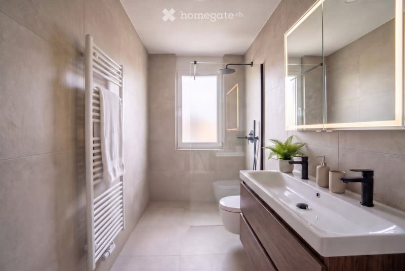 Modern bathroom with a large sink, mirror, toilet, towel rack, and a small plant on the counter.