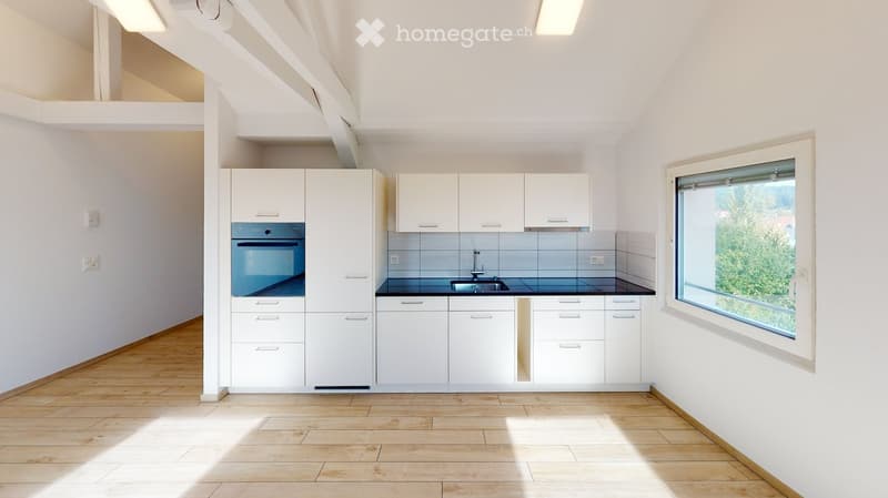 Modern kitchen with white cabinets, a sink, a faucet, and an oven, featuring a large window with a view of greenery.