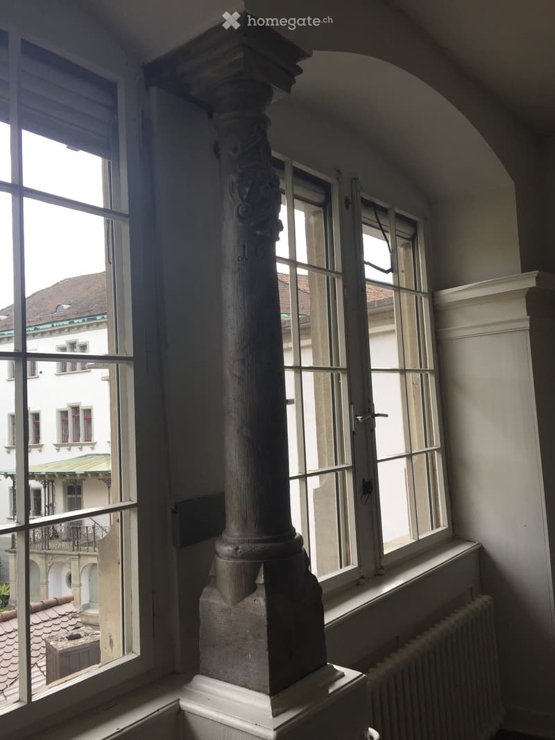 Large windows, wooden pillar, view of building outside