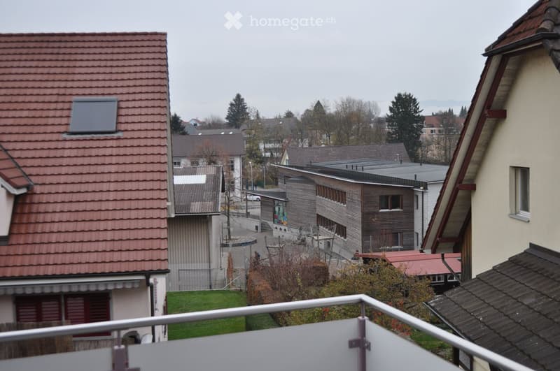 View of a residential area with multiple houses, red-tiled roofs, and a mix of modern and traditional architecture.