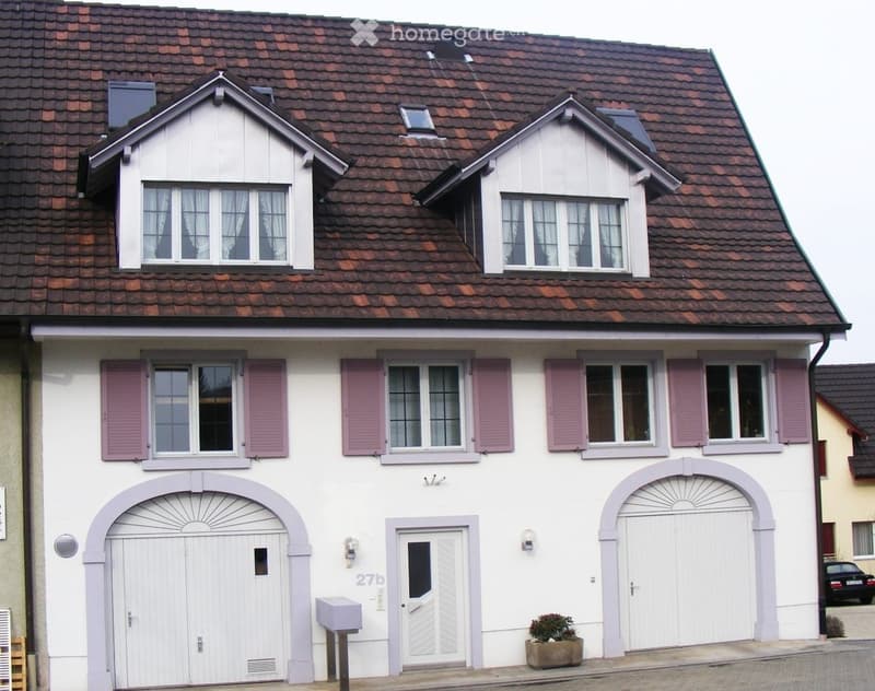 Two-story house with white exterior, red-tiled roof, multiple windows with pink shutters, and a garage entrance.