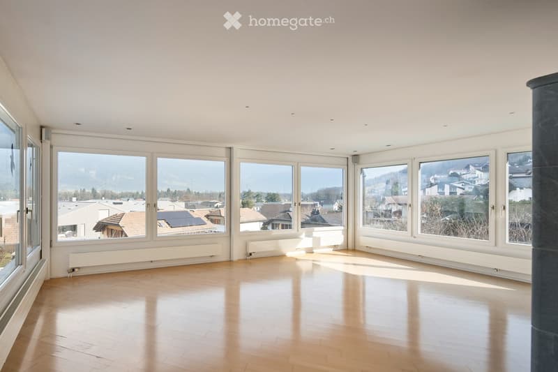Empty room with wooden flooring, large windows, and radiators along the walls. No furniture or equipment present.