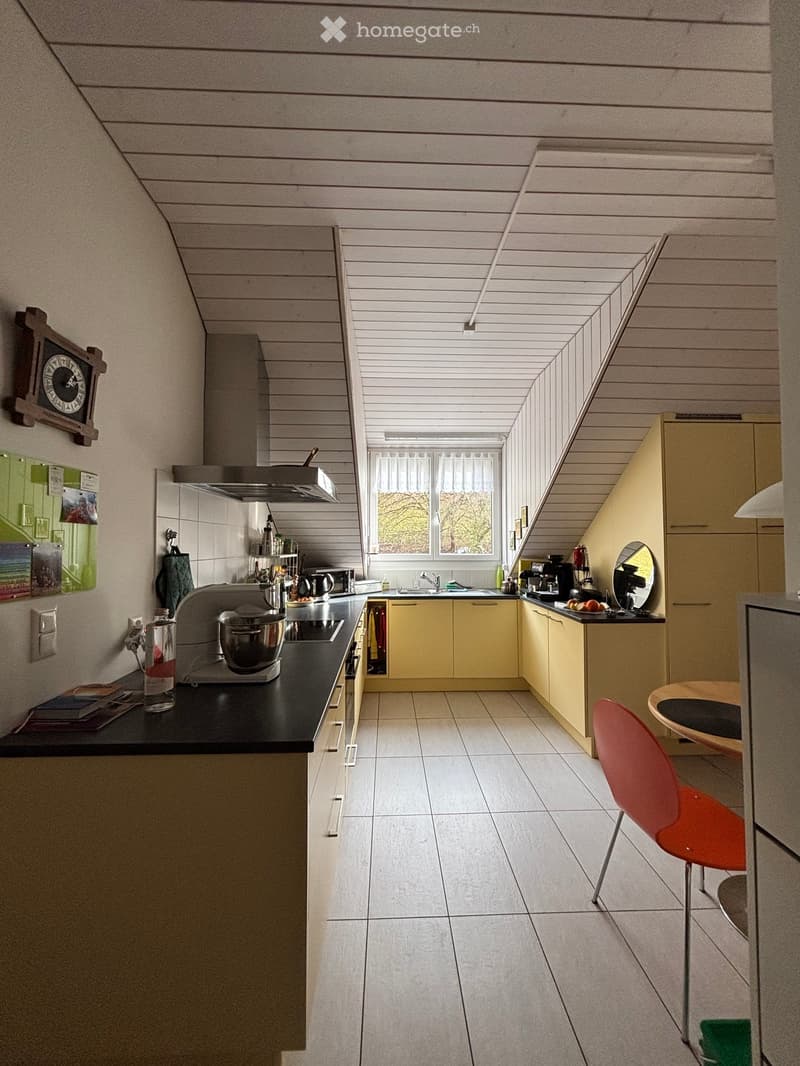 kitchen with yellow cabinets, black countertops, white tiled floor, appliances, and a window