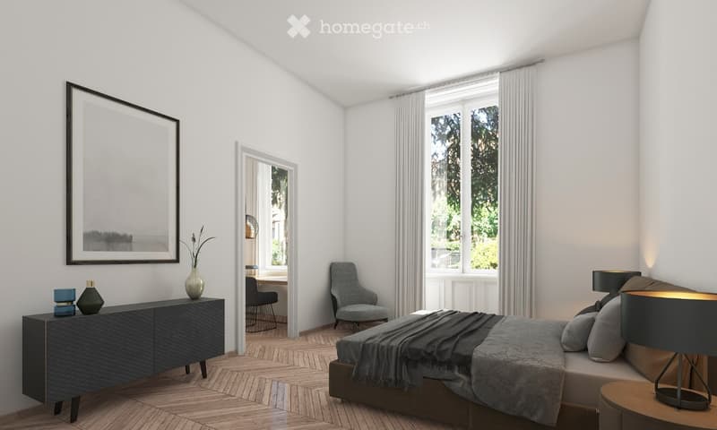 Modern bedroom with a large bed, nightstand, armchair, side table, cabinet, and decorative items. Large windows with sheer curtains and a view of greenery.