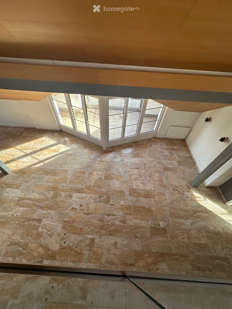 Large windows, tiled floor, wooden ceiling beams