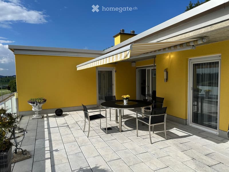 yellow exterior, balcony, round outdoor table, canopy awning, yellow flowers, black chairs, planter with plants, outdoor decor objects